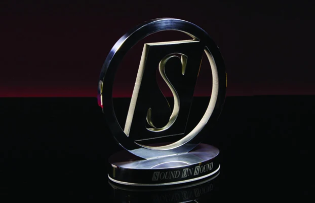 A circular award with an S in the middle, sitting in the shadows