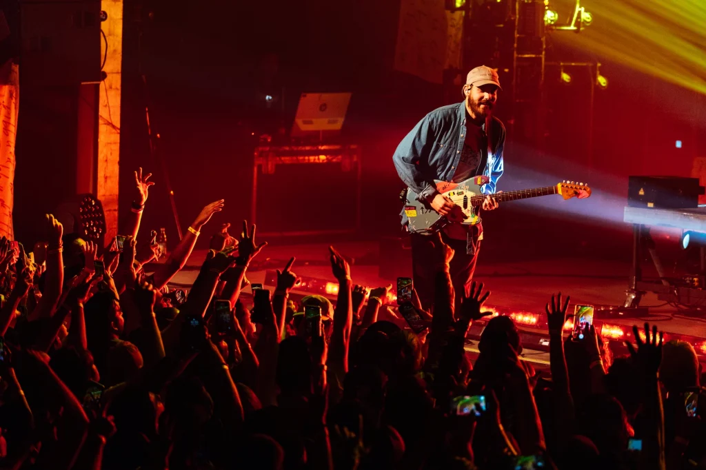 San Holo playing the guitar on stage