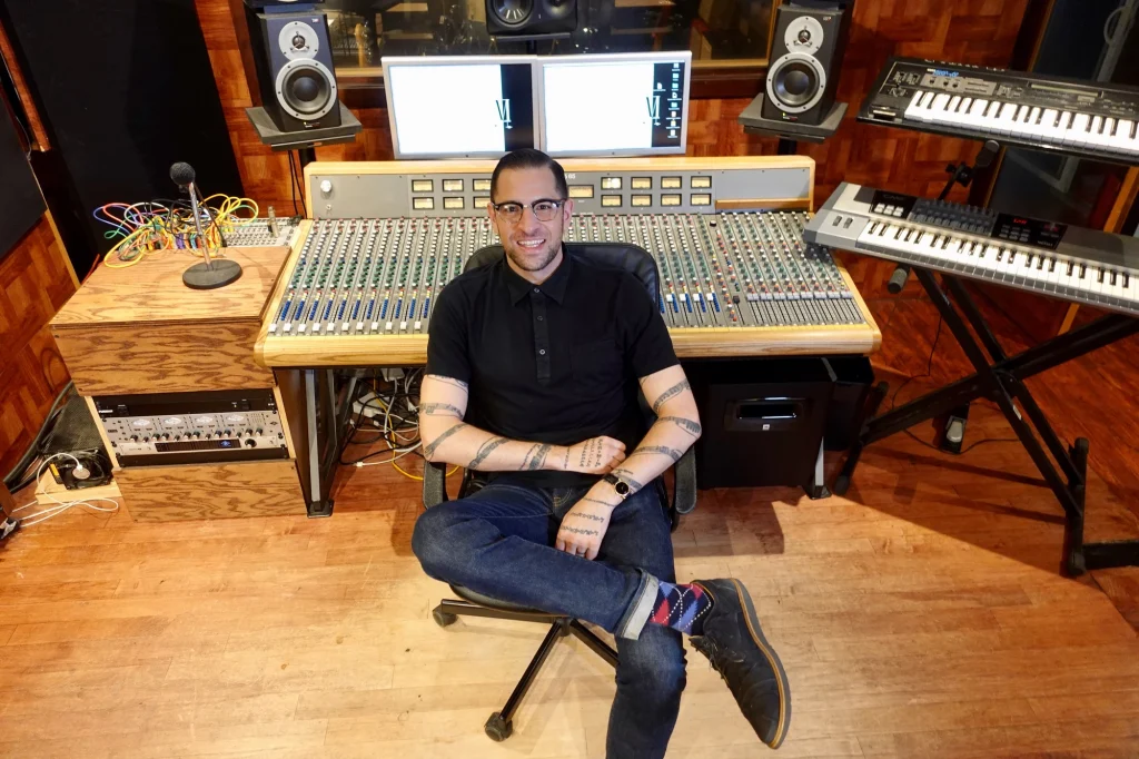 Roman Molino Dunn sitting with his back to an audio workstation
