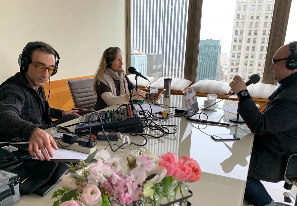 Three people sitting in an office conference room conducting an audio interview