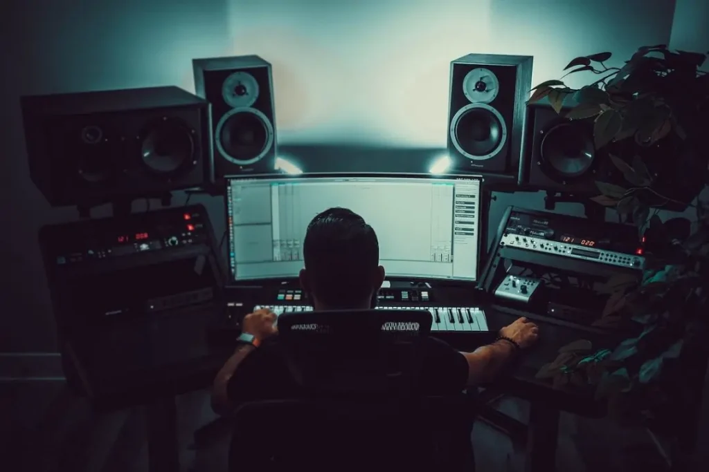 Man sitting in front of a computer in a home studio