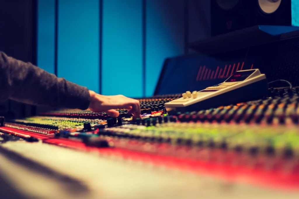 A hand reaching out to adjust levels on a mixer