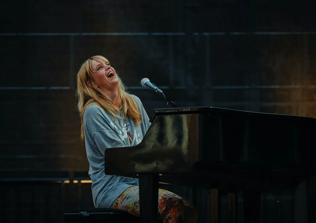 A woman performing and playing the piano