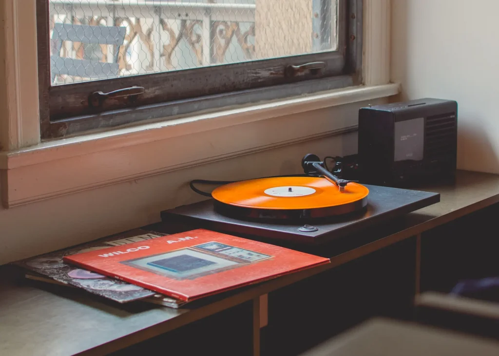 An orange vinyl record playing on a turntable