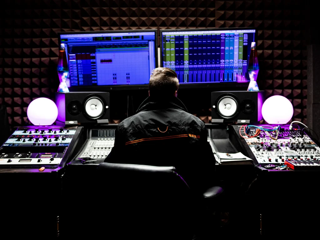 A man sitting in front of a double monitor computer