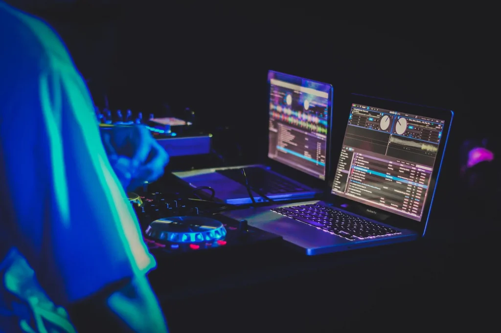 A close up of two laptops running audio mixing software