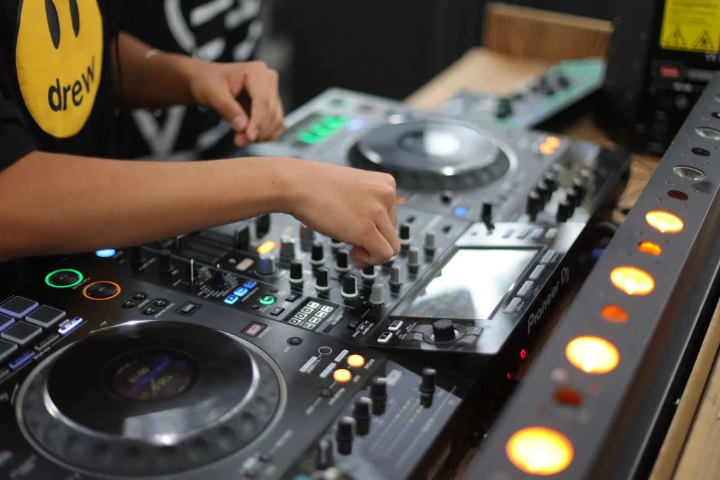 A hand turning a knob on an audio mixer