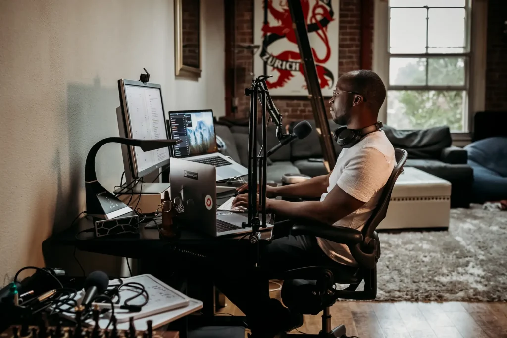 Man in a home studio sitting in front of a computer