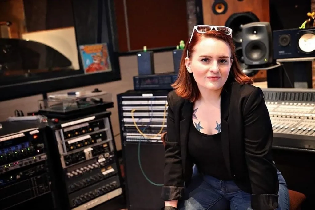 A woman sitting in a recording studio.