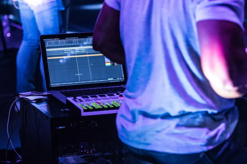 An image of a torso with a laptop running a DAW in the background