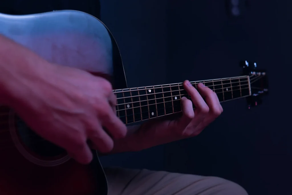 Two hands playing a guitar