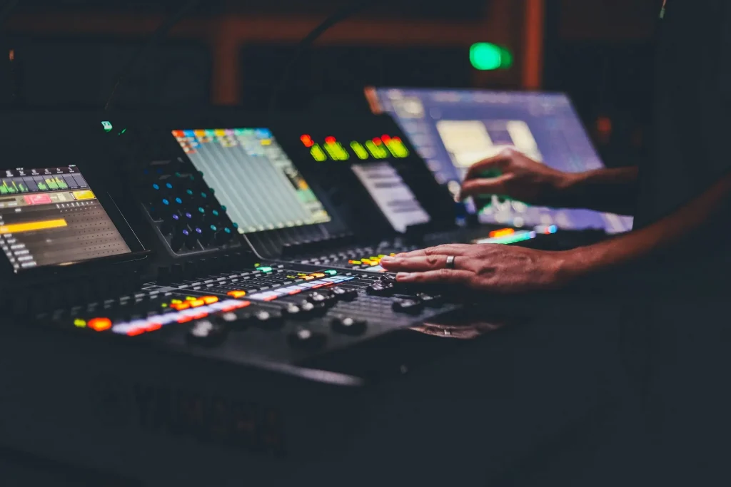Two hands adjusting levels on a mixing console