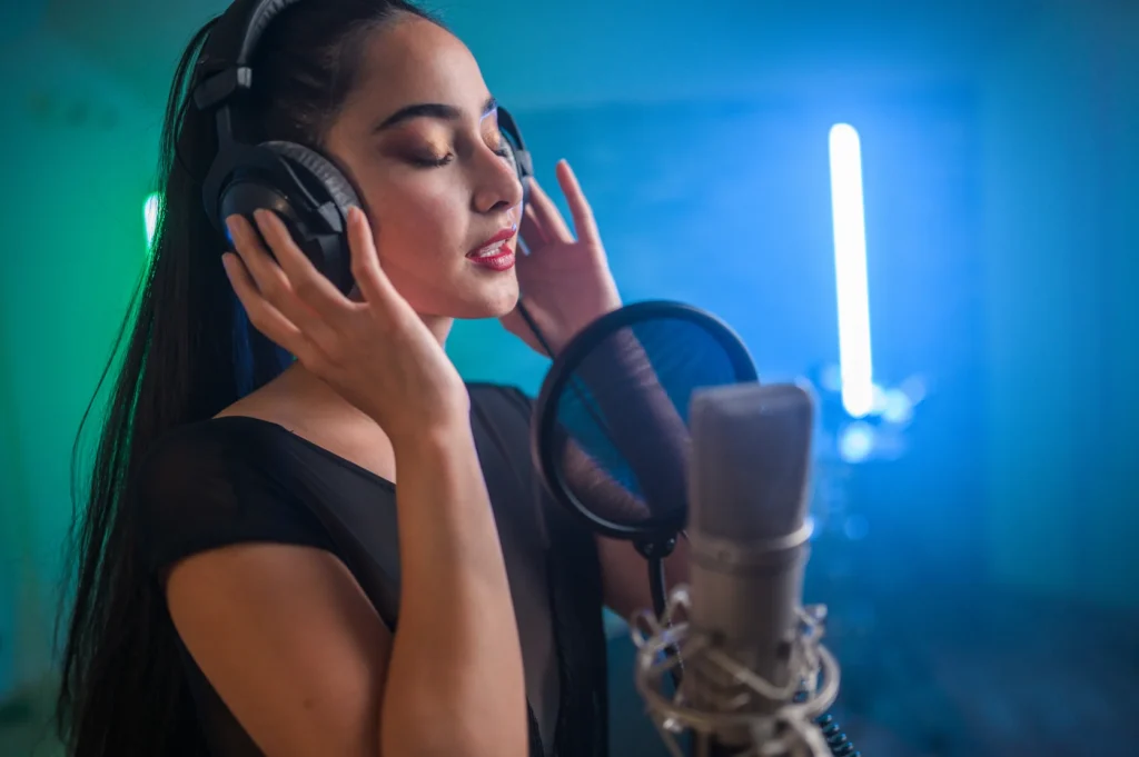 A woman wearing headphones singing into a microphone