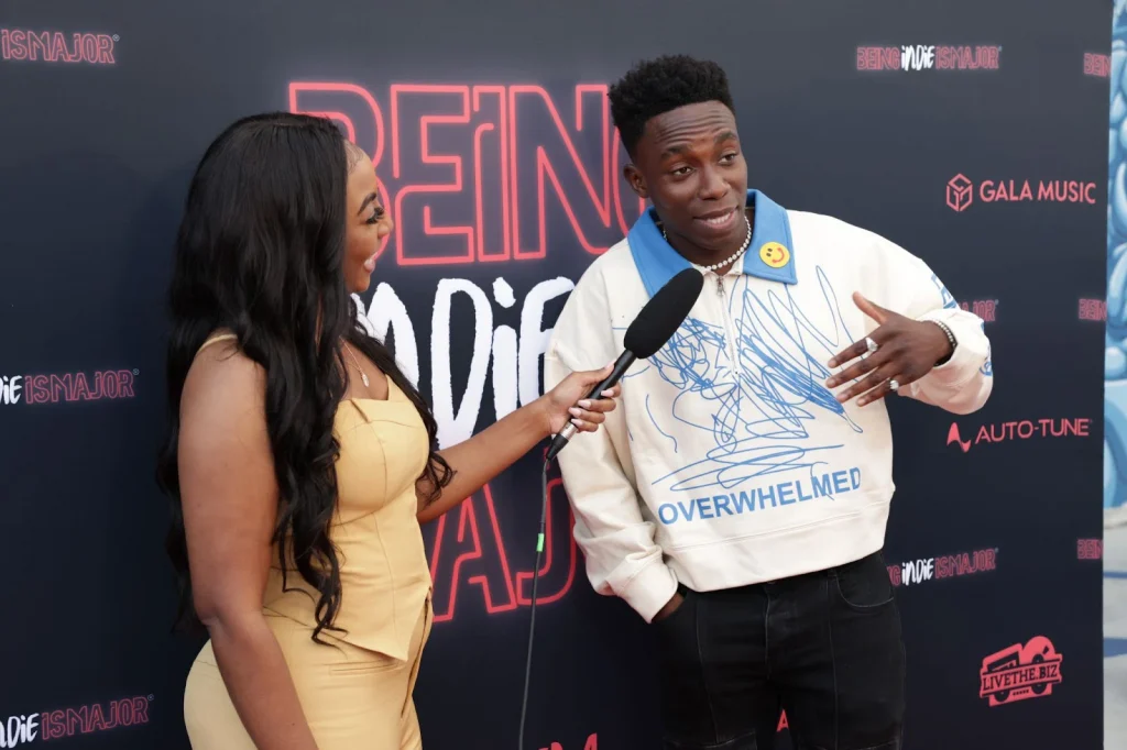 A man getting interviewed by a woman holding a microphone